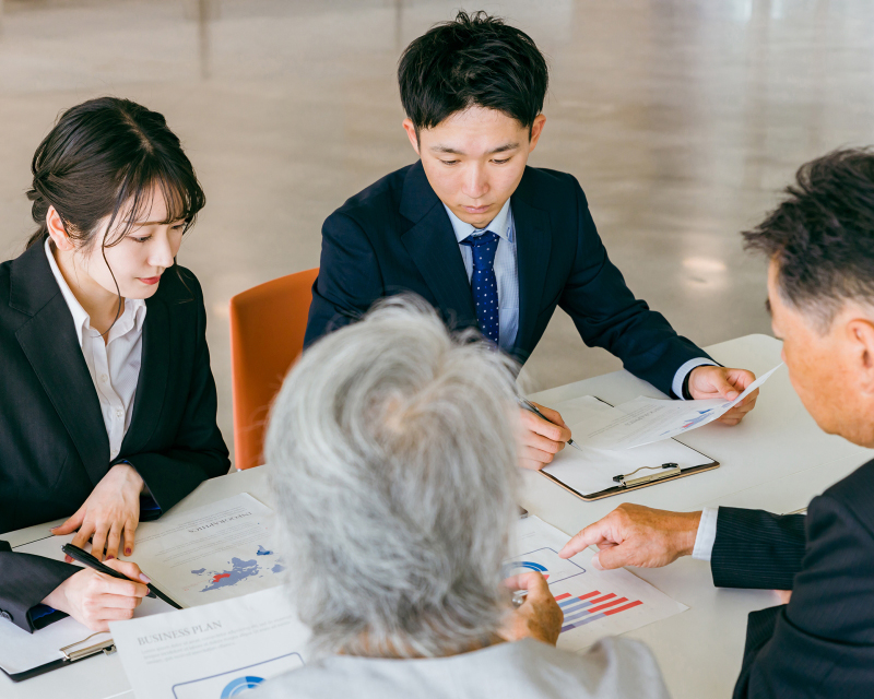資料を見ながら会議をする社会人